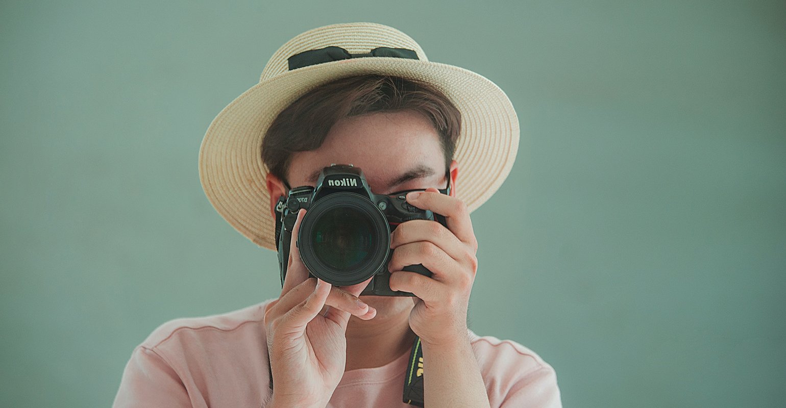 Ein Mann haelt eine Kamera